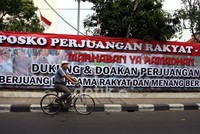 Seorang pengendara sepeda melintas di depan poster raksasa Jokowi-Ahok yang dipasang di depan Posko Perjuangan Rakyat (Posper) di Jalan Diponogoro, Jakarta Pusat. (Ramses/detikcom)