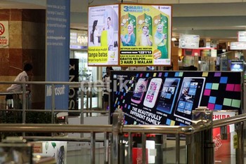 Pengunjung mal di sebuah papan baliho paket Ramadan. Pulsa , tarif dan bonus terbaru ditawarkan selama Ramadan.
