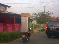Malah, selain membawa kulkas, pengendara motor ini juga membawa sebuah kotak kardus. Hal ini biasanya dilakukan oleh para penjual kulkas demi mengirit biaya. Foto kiriman Ike Marthafuri Yatim.