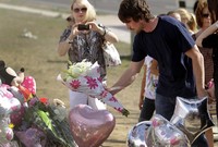 Christian Bale menaruh bunga sebagai tanda duka citanya. (Joshua Lott/Getty Images).