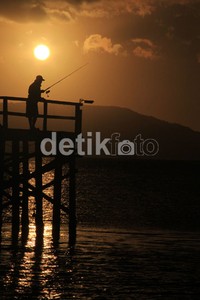 Wisatawan menanti matahari terbit sembari memancing. (Budi Sugiarto/detikcom).