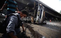 Petugas memasang rantai untuk menarik truk bernopol B 9760 DM tersebut.