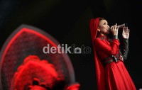 Dibalut busana muslim berwarna merah, Ayu tampak cantik.