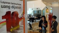 Seorang Costumer Service memberikan pelayanan kepada pelanggan.