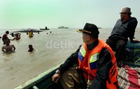 Camat Muara Gembong Adeng Hudaya memantau proses evakuasi bangkai bayi paus dengan menggunakan perahu nelayan.