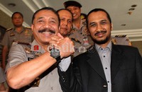 Ketua KPK Abraham Samad berjabat tangan dengan Kapolri Timur Prodopo. Sebelumnya KPK telah menjerat Irjen Pol Djoko Susilo atas kasus dugaan korupsi alat simulator SIM. Namun walau menjadi tersangka, Djoko tetap akan dipertahankan posisinya sebagai Gubernur Akpol.