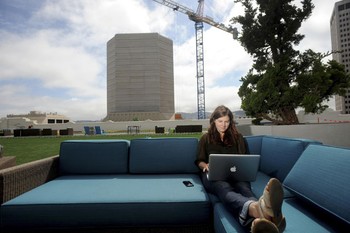 Community Relations Manager Jenna Sampson bersantai bekerja di rooftop kantor.