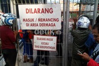 Warga hanya bisa melihat dari kejauhan karena pintu masuk dermaga dijaga ketat oleh petugas. (Robert/detikNews).