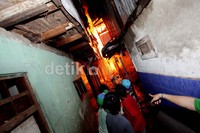 Warga dengan petugas pemadam berjibaku memadamkan api.