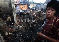 Seorang warga meratapi rumahnya yang hangus terbakar.