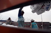 Para pekerja sedang sibuk melakukan pengepakan barang untuk diangkut ke atas kapal