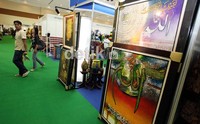 Pengunjung pameran Indonesia Fashion and Craft 2012, melintas di salah satu stand seni kaligrafi, di JCC Senayan, Jakarta, Rabu (8/08).