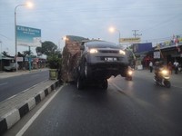 Roda mobil terangkat ke atas. Tumpukan kardus sampai menjulang lebih tinggi dari mobil. (Foto Niko Satria)