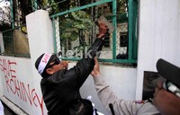 Pendemo berusaha menembus gerbang Kedubes Myanmar dengan mendobrak menggunakan batu. Namun usaha itu gagal karena polisi menenangkan massa.