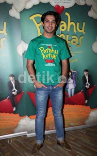 Reza Rahadian memerankan peran Remi, atasan Kugy di perusahaan periklanan.