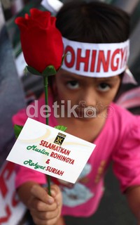 Massa juga membagikan bunga kepada pengendara yang melintas.