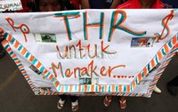 Dalam aksinya mereka membawa amplop raksasa untuk Menteri Tenaga Kerja dan Transmigrasi Muhaimin Iskandar.