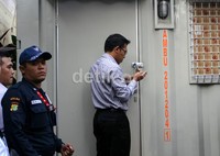 Petugas KPK membuka gembok yang sudah teronggok hampir 2 pekan di pintu kontainer. (Ramses/detikcom).