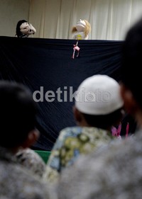Pertunjukan boneka menghibur anak-anak sebelum acara dimulai.