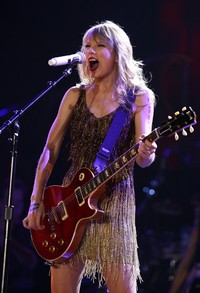 Pada 2 Maret 2012, Taylor Swift beraksi dengan gitarnya saat tampil di Perth, Australia. Paul Kane/Getty Images.