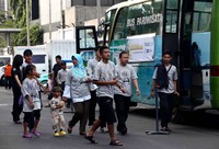Para karyawan Trans Corp berjalan menuju bus yang akan ditumpanginya. Mudik gratis yang diadakan Trans Corp ini dengan tujuan Yogyakarta dan Surabaya.