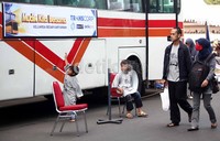 Beberapa anak bermain di sekitar bus yang akan mengantar mereka ke kampung halaman.