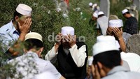 Peziarah berdoa di makam keluarganya.