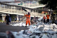 Petugas kebersihan mengumpulkan kertas koran yang ditinggalkan jamaah di Jl Jenderal Urip Sumoharjo, Matraman, Jakarta, Minggu (19/8/2012).