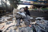 Tidak hanya petugas kebersihan, petugas keamanan pun turut mengumpulkan kertas koran yang berserakan di tengah jalan.