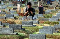 Seorang warga memanjatkan doa di makam keluarganya. (Ramses/detikcom).