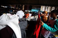 Seorang warga memilih baju bekas yang akan dibelinya.