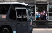Warga menunggu bus yang akan ditumpanginya di Halte Dukuh Atas.