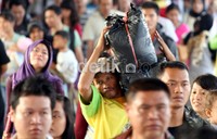 Seorang kuli panggul membawa barang milik penumpang kereta api Bogowonto jurusan Yogya-Jakarta saat tiba di Stasiun Senen. Ramses/detikcom.
