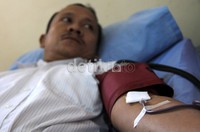 Seorang warga mendonorkan darahnya.