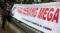 Relawan Jokowi-Basuki mencopot spanduk bertuliskan Jokowi Menang Mega Presiden.