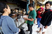 Seorang warga menunjukkan berkas pengambilan paket.