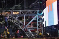 Pekerja melakukan tugasnya dengan teliti. Sudut lampu, komposisi dan tata panggung diterapkan secara seksama untuk membuat gambar dan proses kampanye berjalan komunikatif, kolosal dan tetap layak jual. (Photo by Mario Tama/Getty Images)