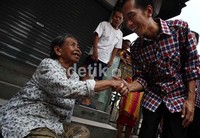 Jokowi menyalami seorang warga yang duduk di depan rumahnya di kawasan Pengadegan.