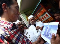 Jokowi melihat gambar bangunan mushola di Menteng Dalam.