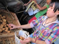 Hup hup! Penjual Tahu Lamping dengan cekatan memasukkan tahu panas ke dalam keranjang. Sepertinya dia sudah biasa memegang tahu panas (Fitraya/detikTravel)