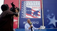 Jurnalis televisi lokal bekerja di tengah arena persiapan konvensi. Badan tropis Isaac dimungkinkan bakal menunda pembukaan konvensi. Konvensi ini juga diramaikan demonstran yang tidak suka gaya kepemimpinan Mitt Romney. (REUTERS/Adrees Latif)