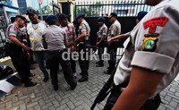 Polisi siaga dengan senjata laras panjang.