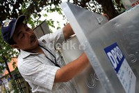 Seorang pekerja merakit kotak suara yang akan didistribusikan.
