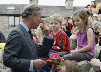 Charles memegang hidungnya saat berbicara dengan anak-anak dalam sebuah pembukaan restoran di Cumbria, Inggris. Ekpresi Charles terlihat natural. (Photo by Owen Humphreys/Anwar Hussein Collection/Getty Images).