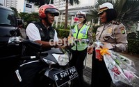 Bunga-bunga tersebut dibagikan kepada para pengendara terutama penggunan sepeda motor.