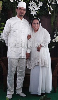 Nunung terlihat mengenakan setelan putih-putih dan selendang senada. Sementara Iyan menggunakan koko dan peci putih.