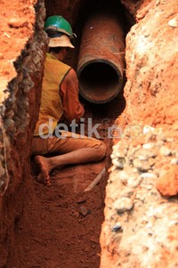 Pekerja melakukan pemasangan pipa air minum.