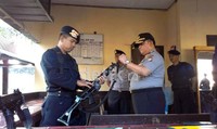Mudji memeriksa laras senapan serbu yang disiagakan di pos markas  Detasemen C Brimob Bone.