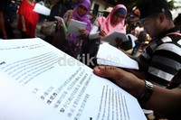 Pembeli membaca buku yang akan dibelinya.