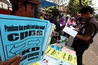 Seorang pedagang menawarkan beragam buku panduan kepada warga yang melintas di depan Gedung Caraka Loka, Hang Lekir, Jakarta Selatan.